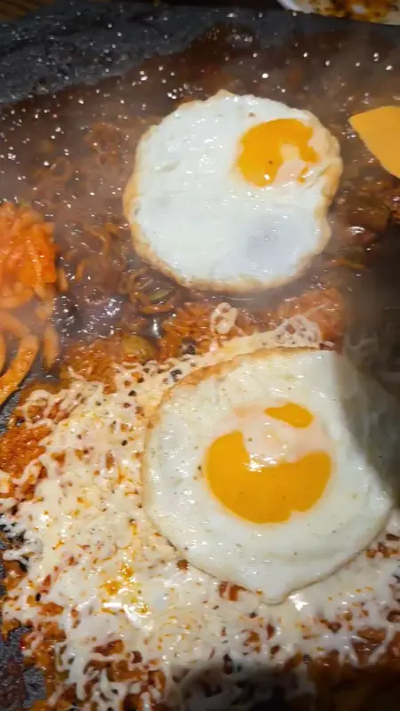 돌판 위에 짜파게티, 계란후라이가 함께 있는 모습