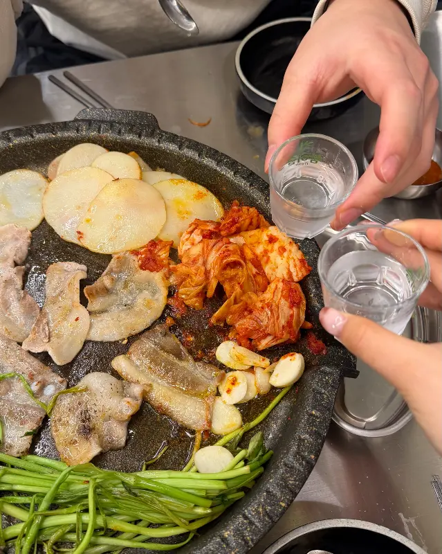 냉동 삼겹살과 함께 술잔을 기울이는 모습