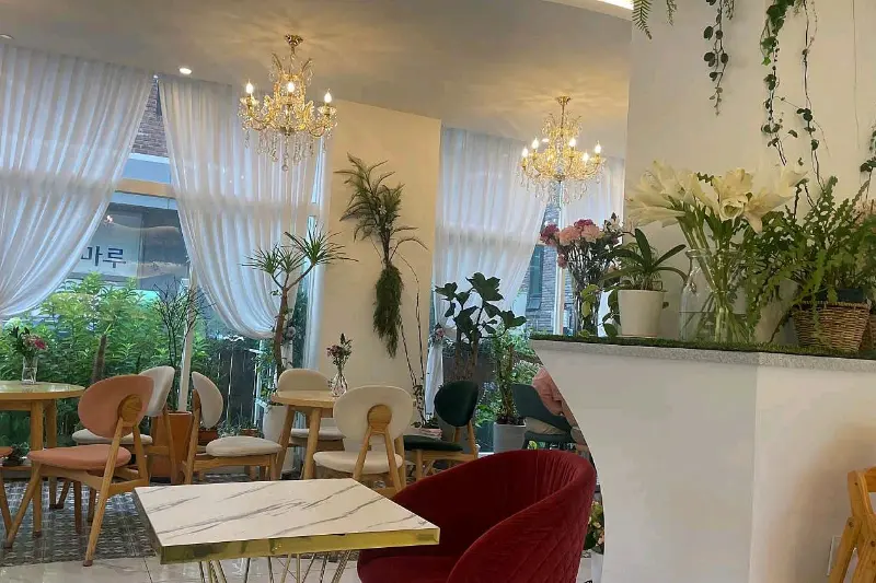 샹들리에와 꽃 장식이 어우러진 카페 내부