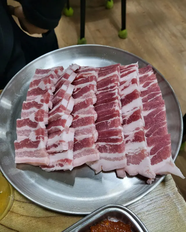 접시에 담겨 나온 삼겹살, 선명한 붉은색과 흰색 지방의 조화가 먹음직스럽다.