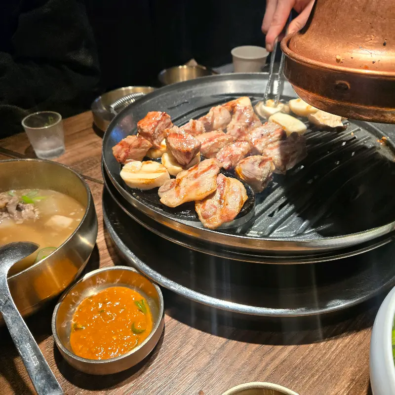 숯불 위에서 익어가는 돼지고기와 마늘