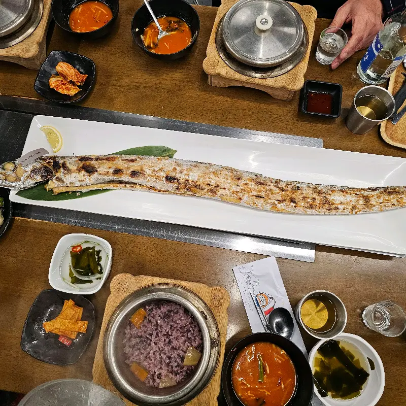 갈치구이와 조림, 그리고 다양한 밑반찬이 한 상 가득 차려진 모습