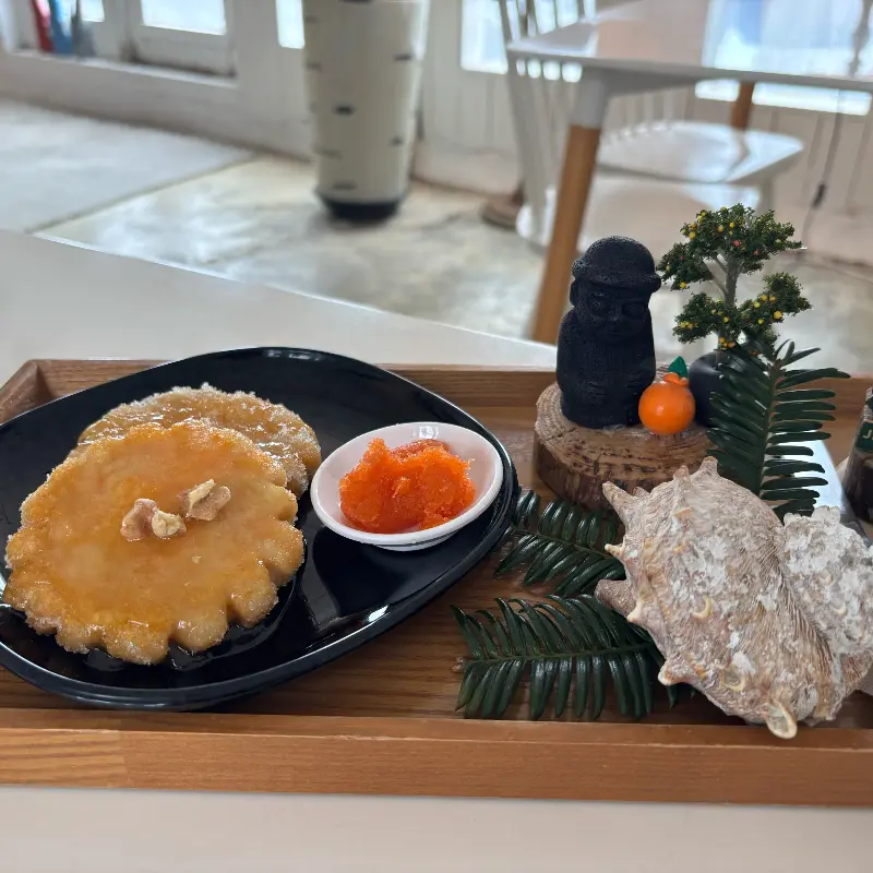 검은색 접시에 담긴 당근 기름떡과 당근 잼