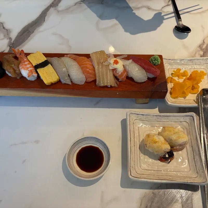 다양한 초밥이 나무 받침에 올려져 있는 모습