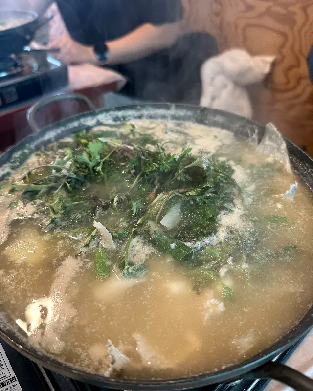 테이블 위에서 끓고 있는 도다리 쑥국