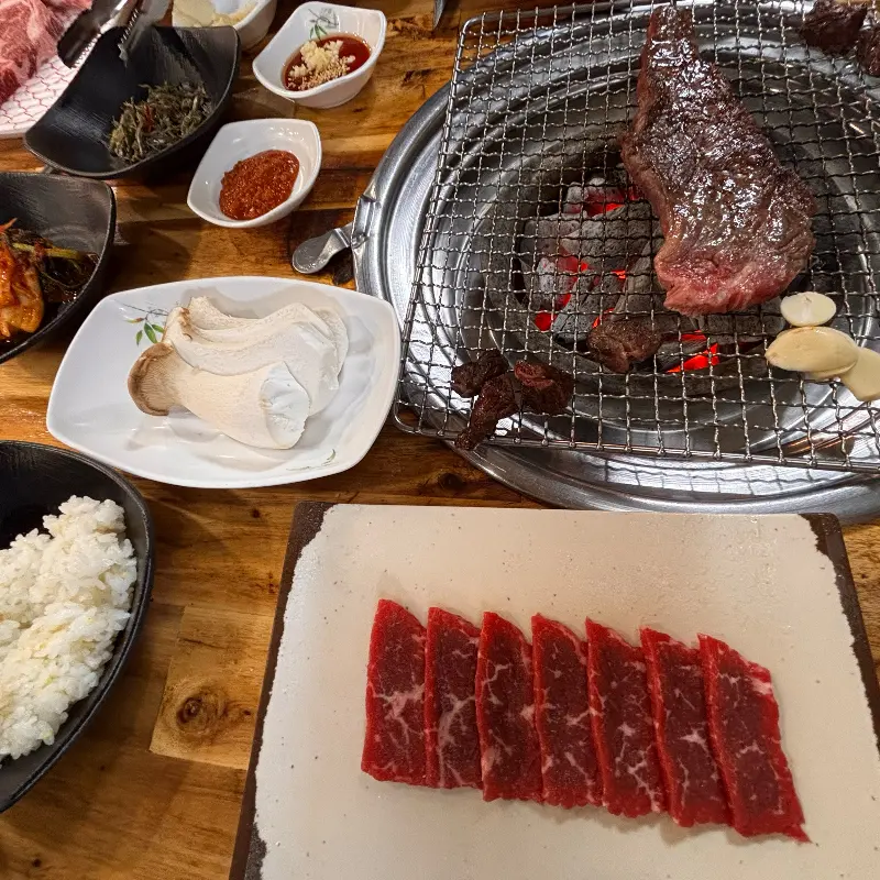 숯불 위에서 맛있게 익어가는 한우와 육사시미