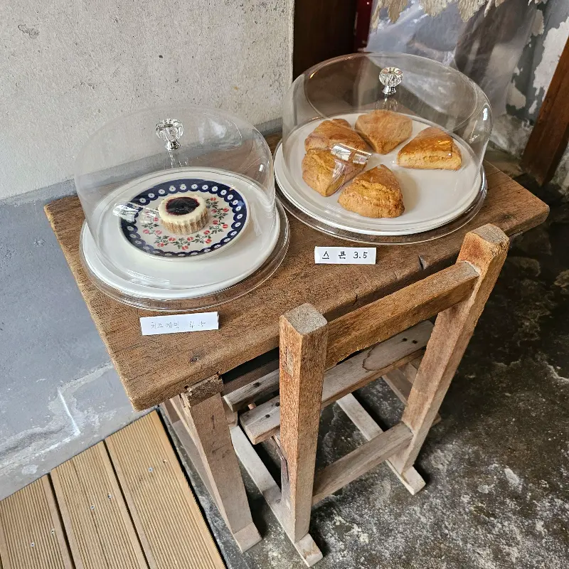 투명한 덮개 안에 담겨 있는 레몬 케이크와 스콘