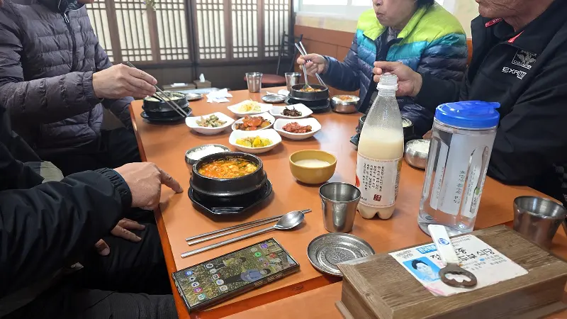 식탁에 옹기종기 모여 앉아 식사하는 손님들