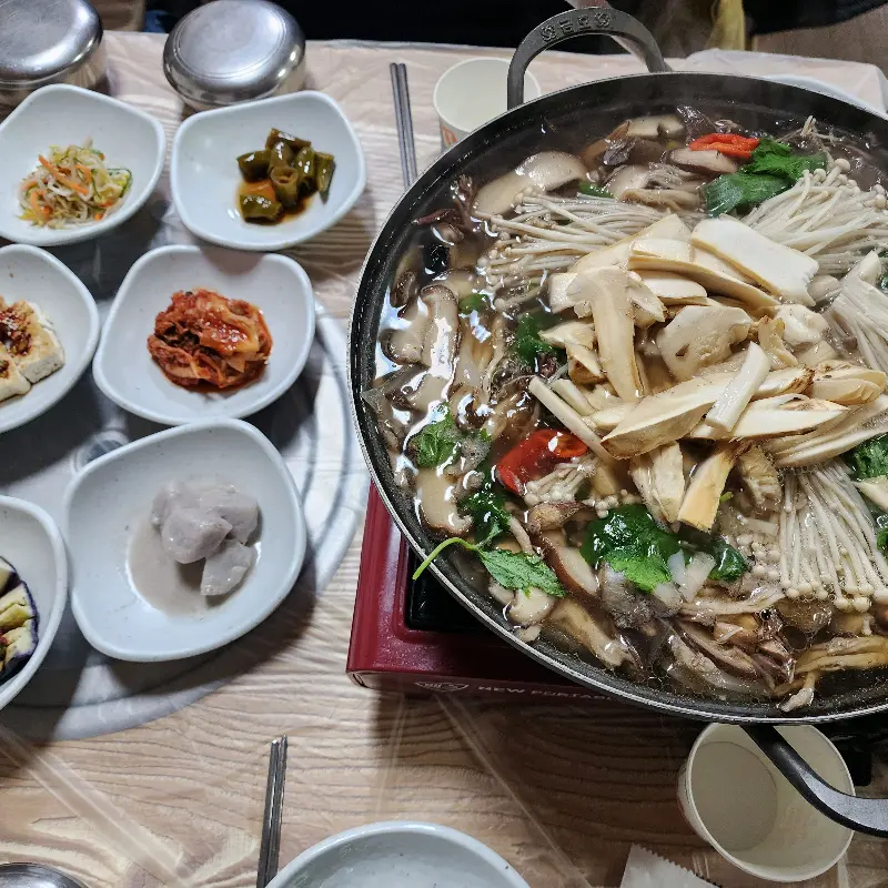 푸짐한 버섯전골과 밑반찬 사진