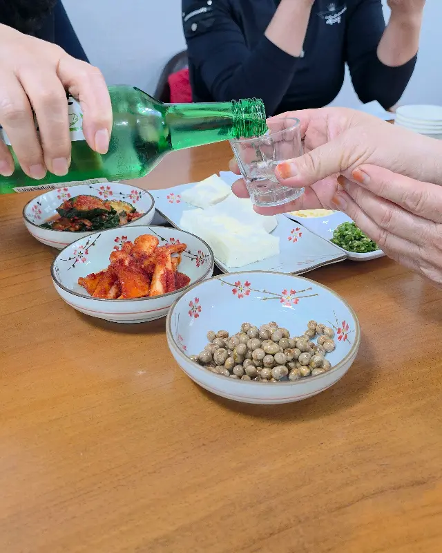 밑반찬과 함께 술 한 잔 기울이는 손님들