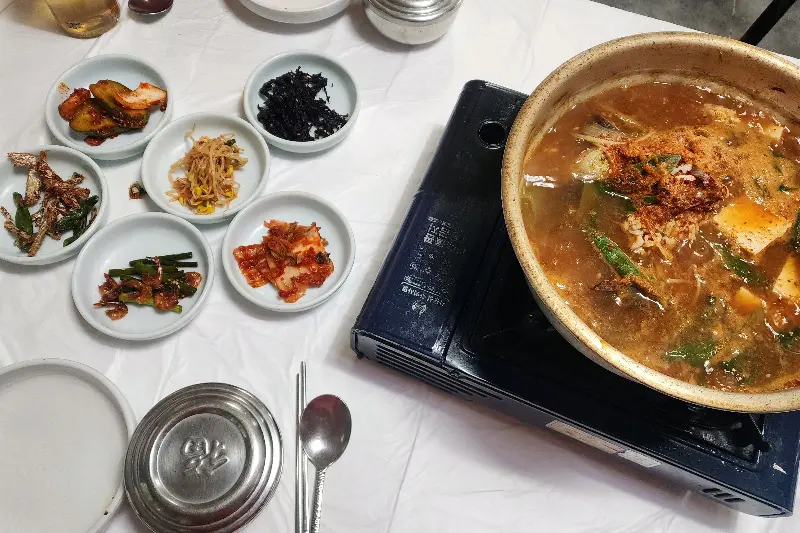 밑반찬과 함께 끓고 있는 동태탕