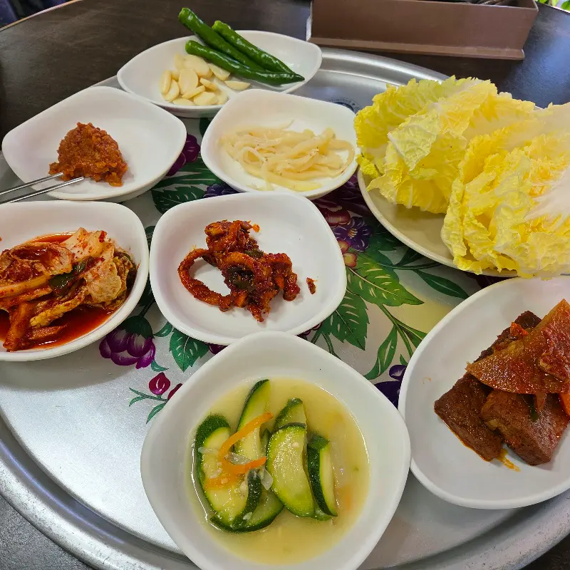 다양한 반찬들이 쟁반에 가득 담겨 있는 모습