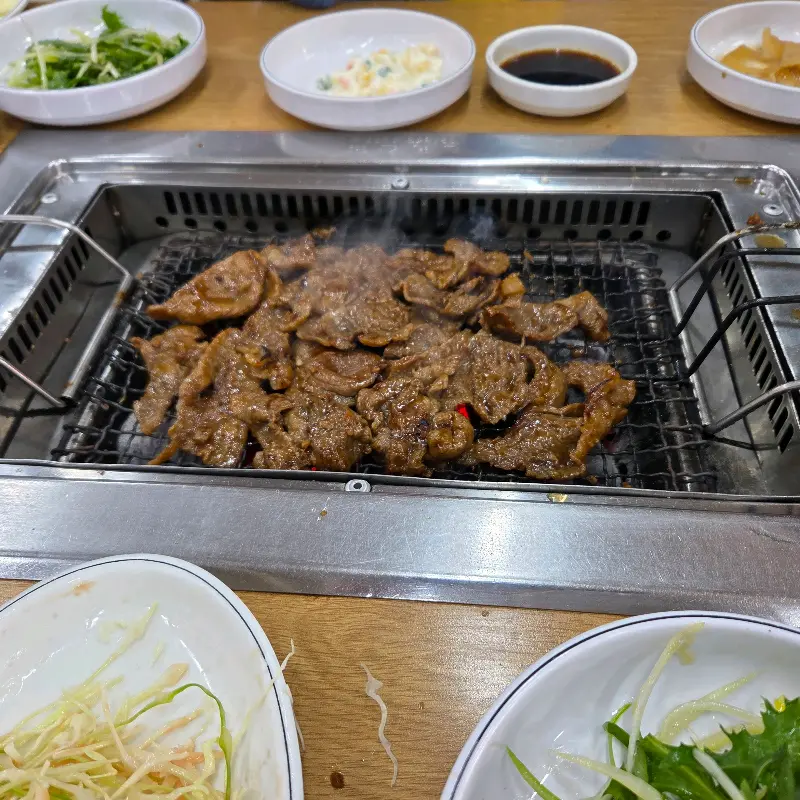 테이블에 차려진 밑반찬과 숯불