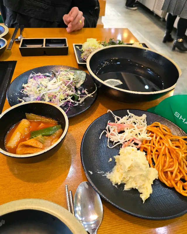 샤브샤브 재료와 샐러드바 음식들이 놓인 테이블