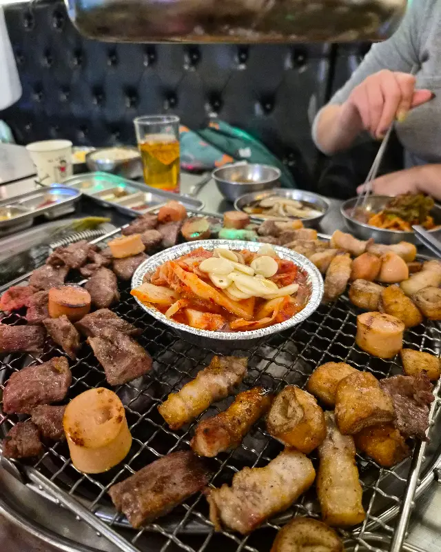 숯불 위에서 맛있게 익어가는 고기와 김치