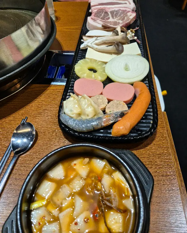 두툼한 삼겹살과 다양한 곁들임 재료가 한 상 가득 차려진 모습