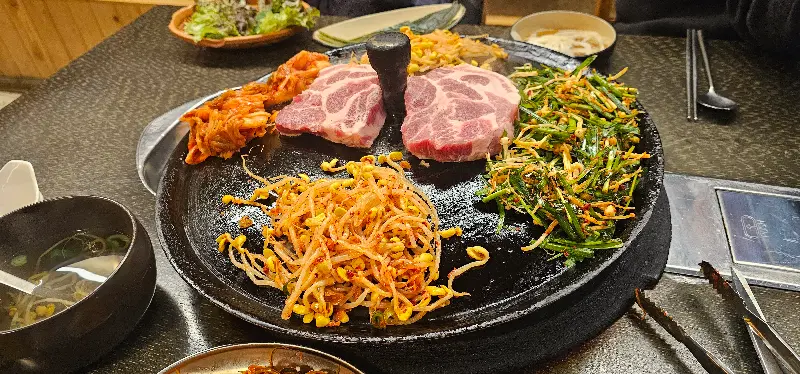 노릇하게 구워진 삼겹살과 콩나물, 김치의 환상적인 조합