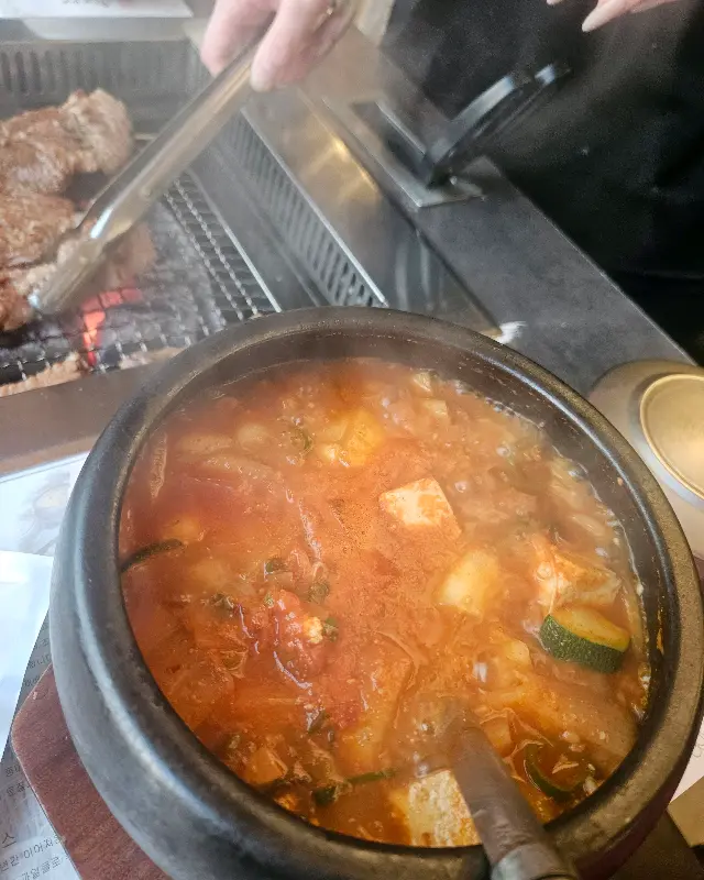 숯불 위에서 구워지는 생갈비와 된장찌개