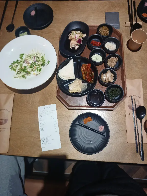 고기와 다양한 곁들임 반찬이 놓인 테이블 전경