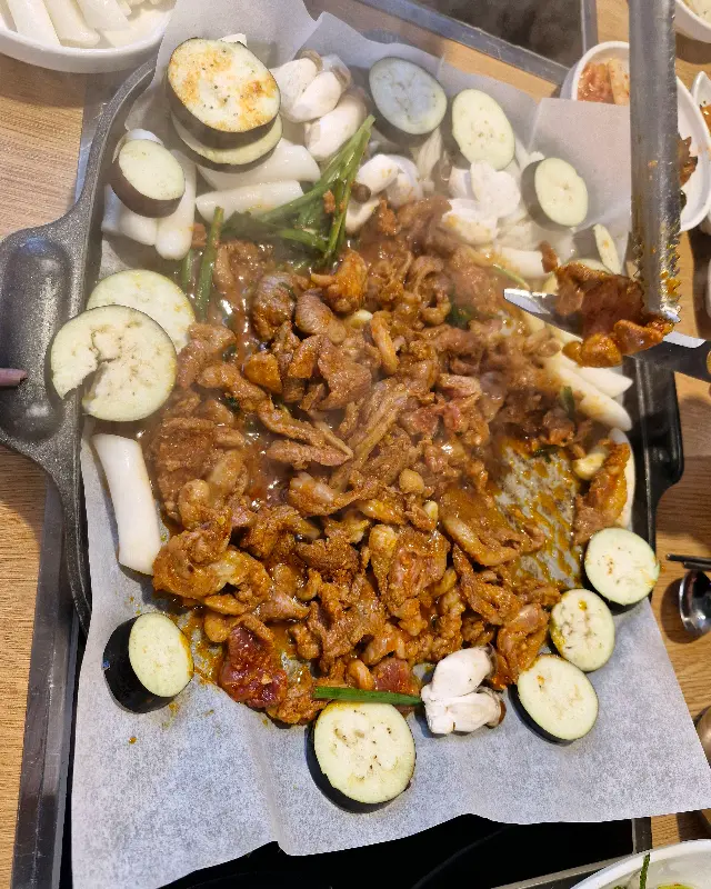 불판 위에서 익어가는 오리고기와 채소들