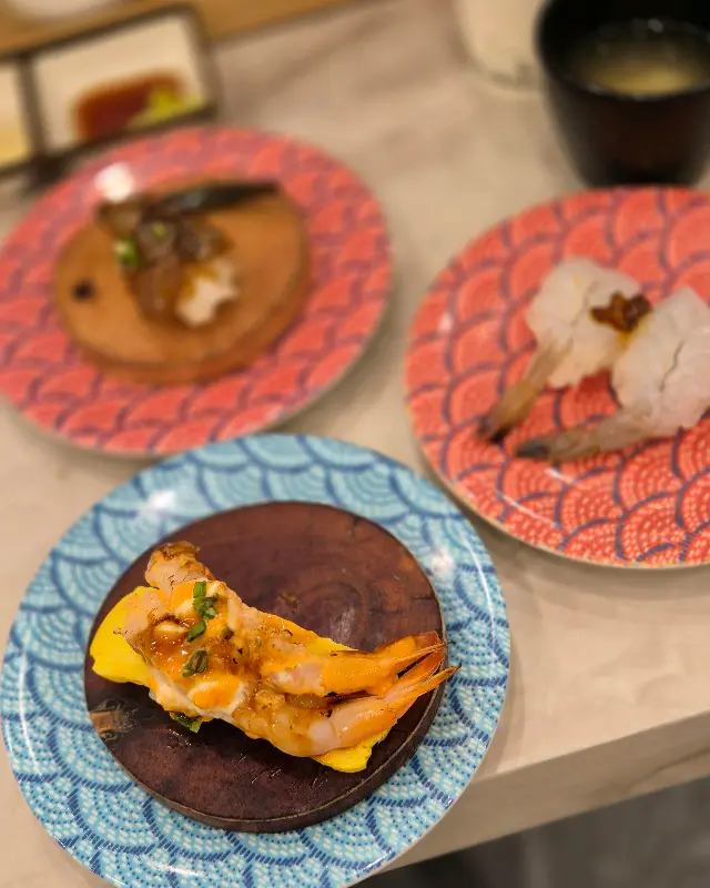 다채로운 색감의 초밥 접시들이 테이블 위에 놓여 있는 모습