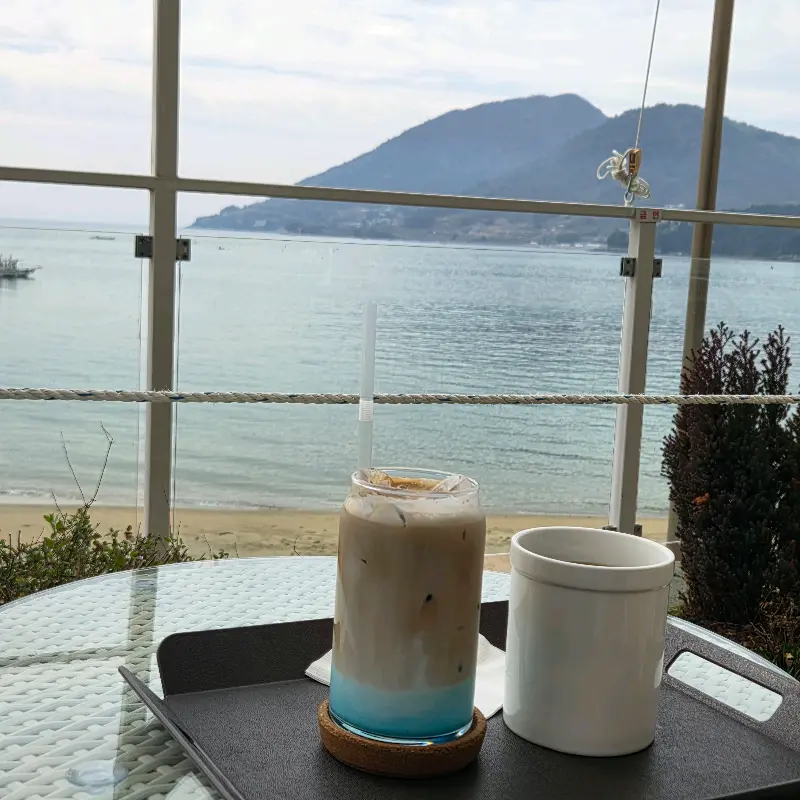 창밖의 바다를 배경으로 놓인 음료