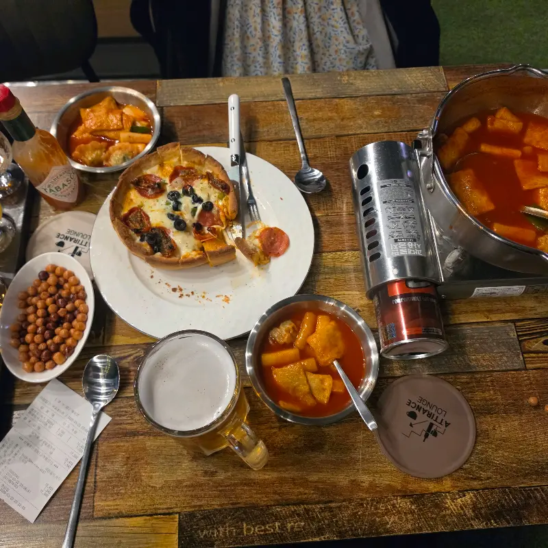 피자와 떡볶이, 맥주가 놓인 테이블