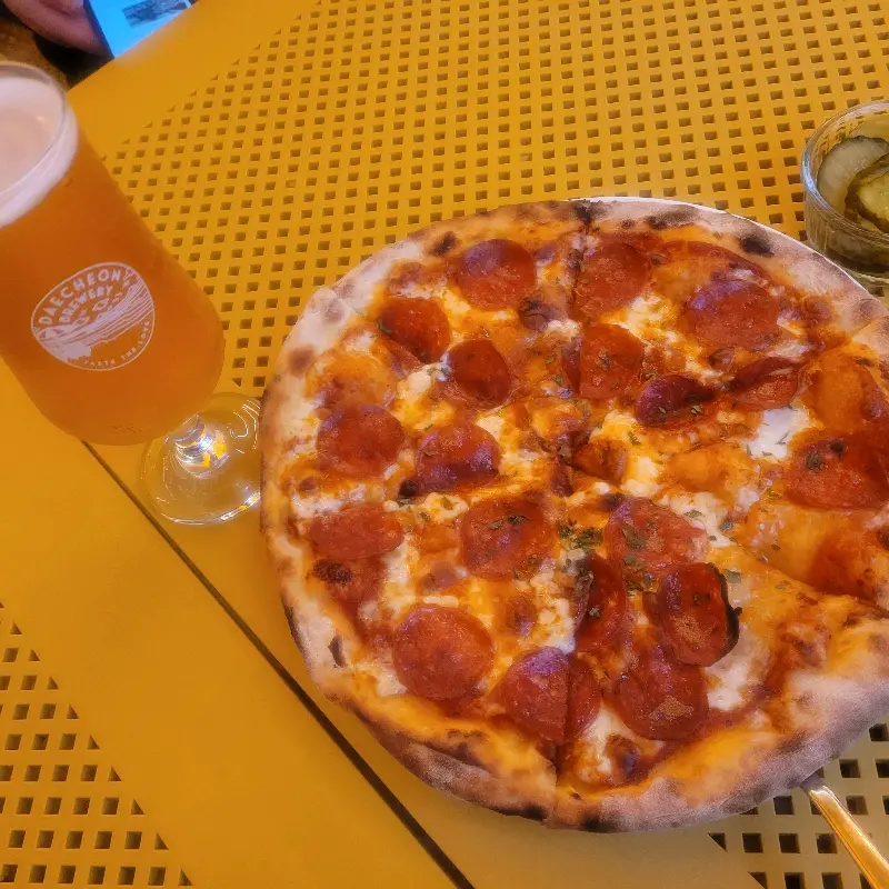 페퍼로니 피자와 맥주가 놓인 테이블 사진