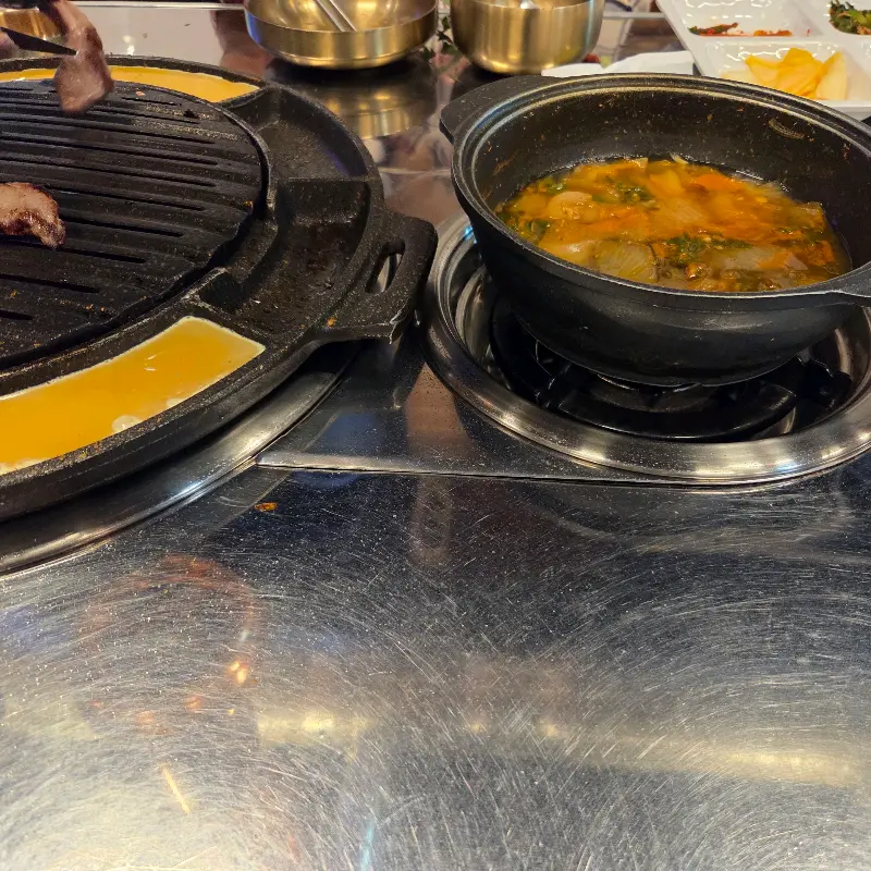 불판 위에서 맛있게 익어가는 갈매기살과 된장찌개