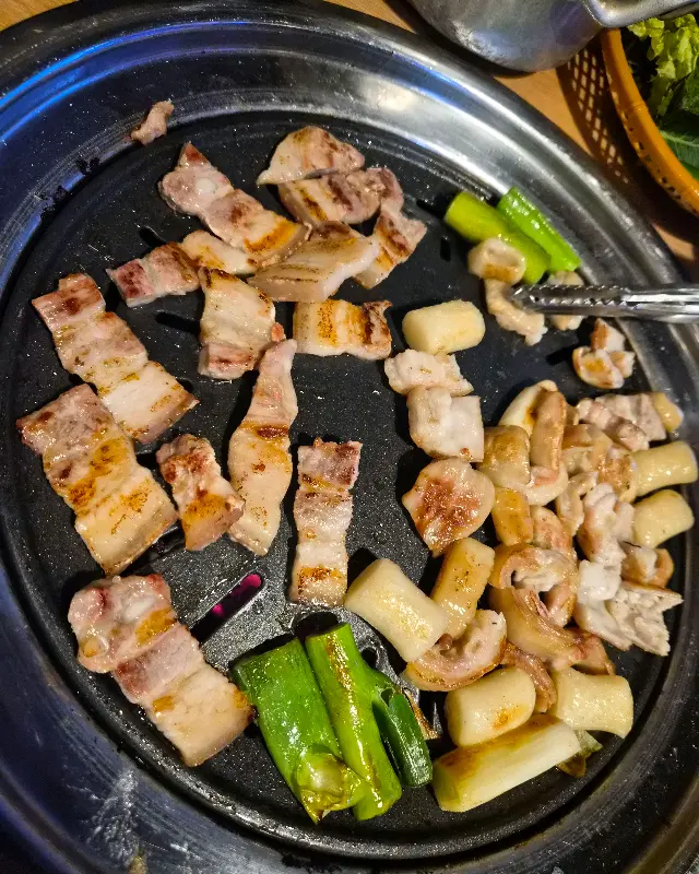 불판 위에서 익어가는 막창과 떡, 파