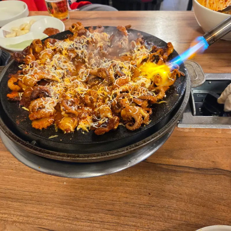 불 맛이 입혀진 쭈꾸미와 녹아내린 치즈의 조화
