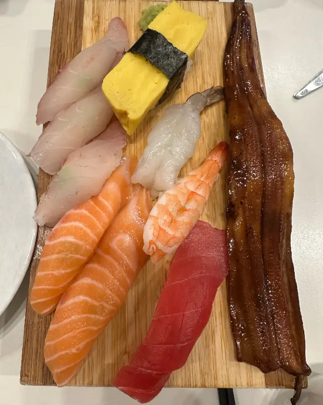 다양한 종류의 초밥이 놓인 나무 플레이트