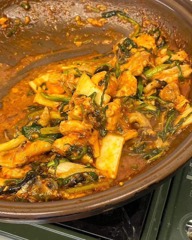 냄비 안에는 복어와 양념, 미나리 등이 섞여 있다.