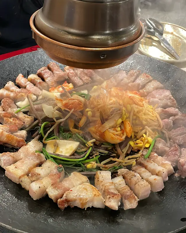 솥뚜껑 가득 채워진 삼겹살