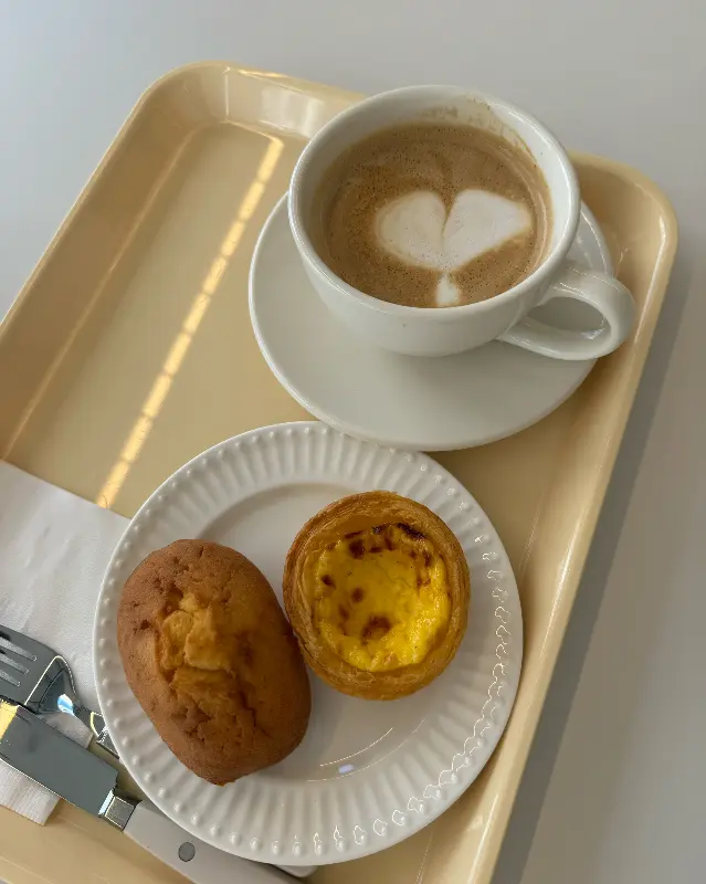 하트 모양 라떼 아트가 인상적인 카페 라떼와 에그타르트, 마들렌