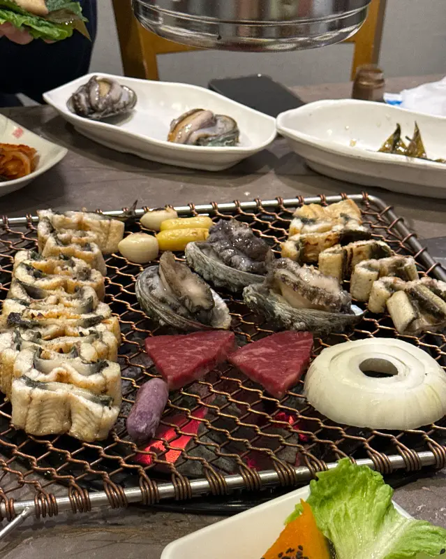 숯불 위에서 익어가는 장어, 소고기, 전복