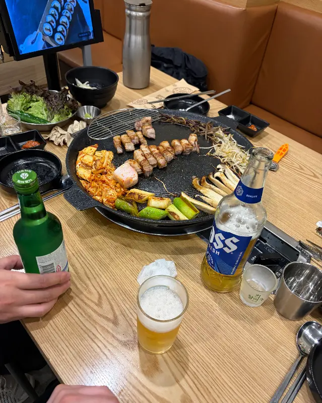 테이블 가득 차려진 밑반찬과 고기