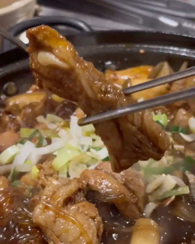 집게로 쫄갈비를 들어올리는 모습