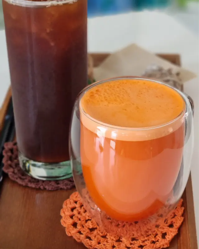 투명한 유리잔에 담긴 주황색 당근 주스