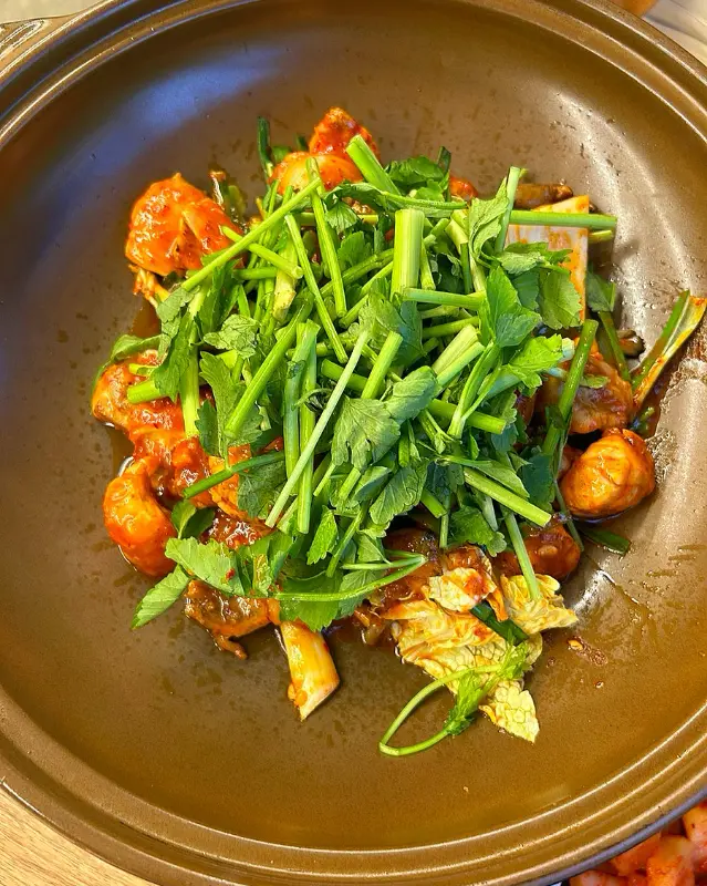 복불고기가 담긴 접시 위로 미나리가 수북하게 올려져 있다.