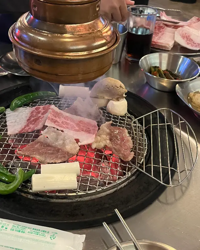 숯불 위에서 익어가는 차돌박이와 버섯