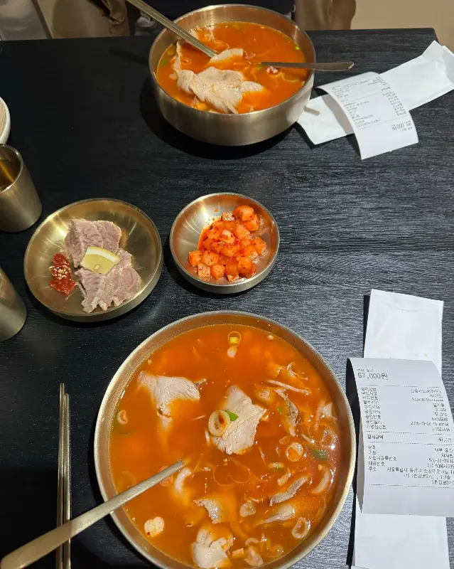 테이블 위에 놓인 열곰탕, 냉제육, 깍두기의 조화로운 모습