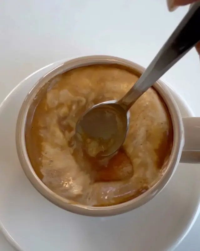 흑임자 라떼를 스푼으로 저어 먹는 모습