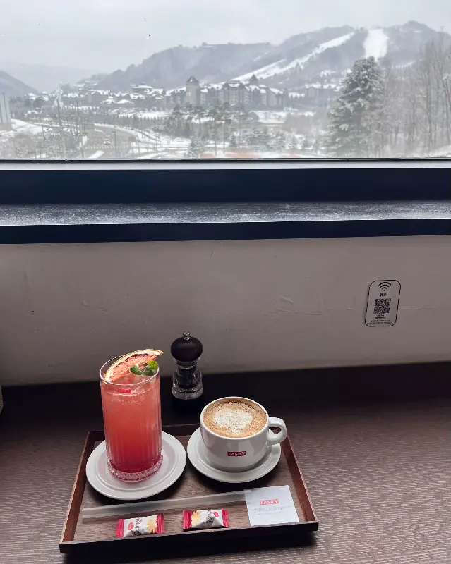 창밖 설산 뷰와 테이블 위에 놓인 음료