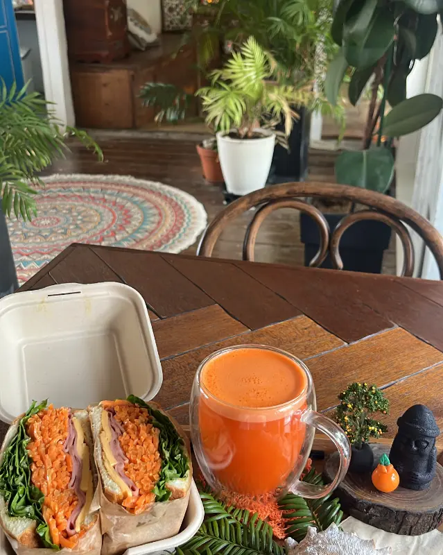 당근 샌드위치와 당근 주스가 나무 테이블 위에 놓여 있는 모습