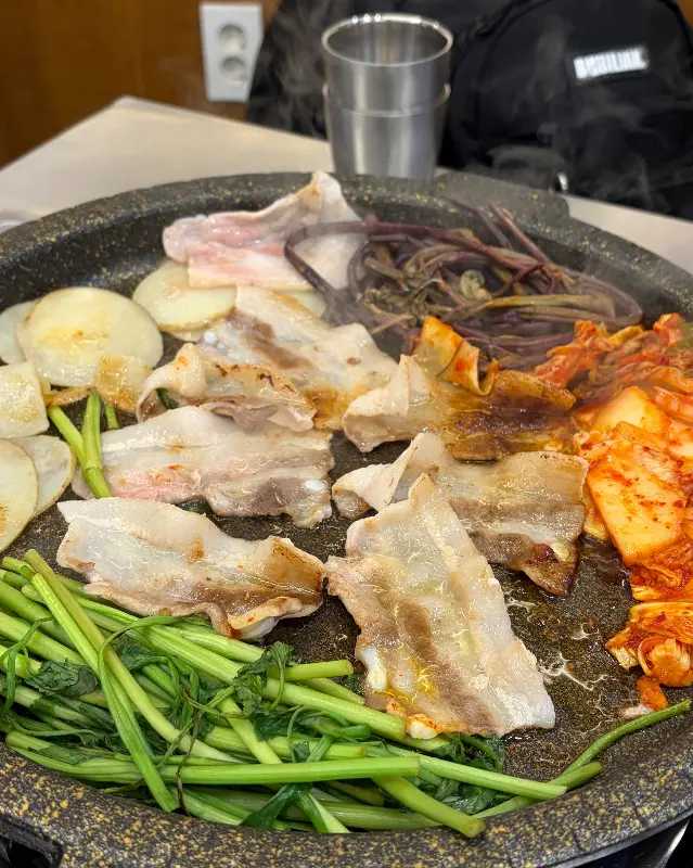 불판 위에서 맛있게 익어가는 냉동 삼겹살