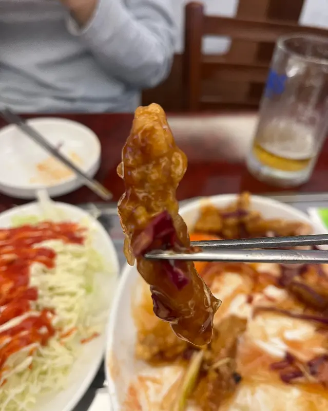 젓가락으로 탕수육을 집어 올린 모습