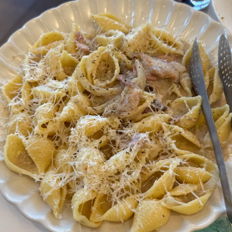 크림 파스타 위에 치즈가 뿌려져 있는 모습