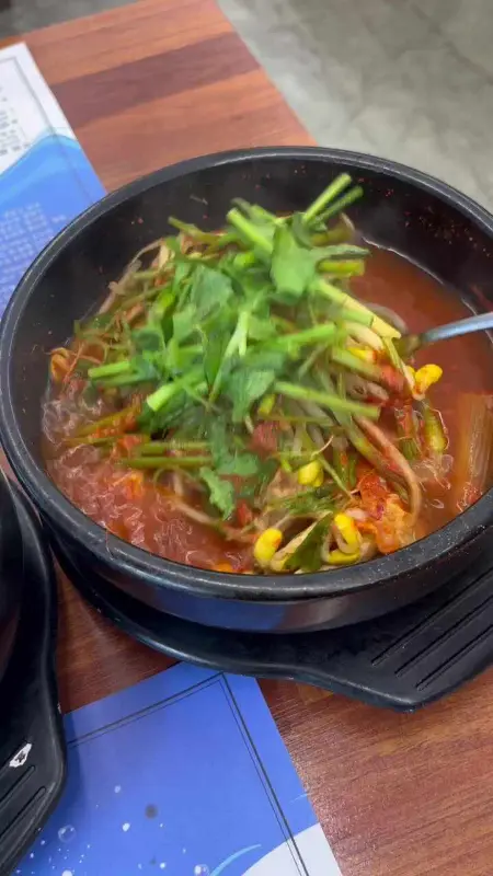 뚝배기에 담긴 복지리에는 미나리와 콩나물이 가득 들어 있다.