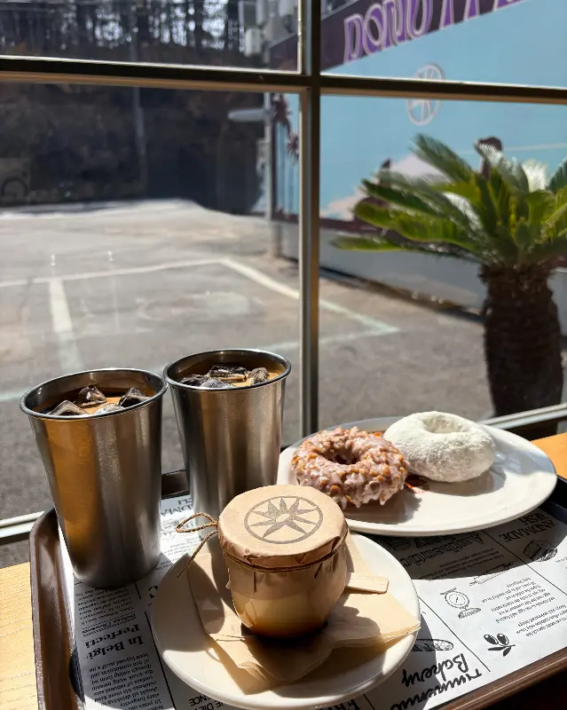 창가 테이블에 놓인 도넛과 커피